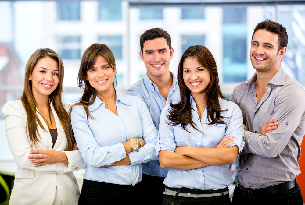 Happy business team with arms crossed at the office